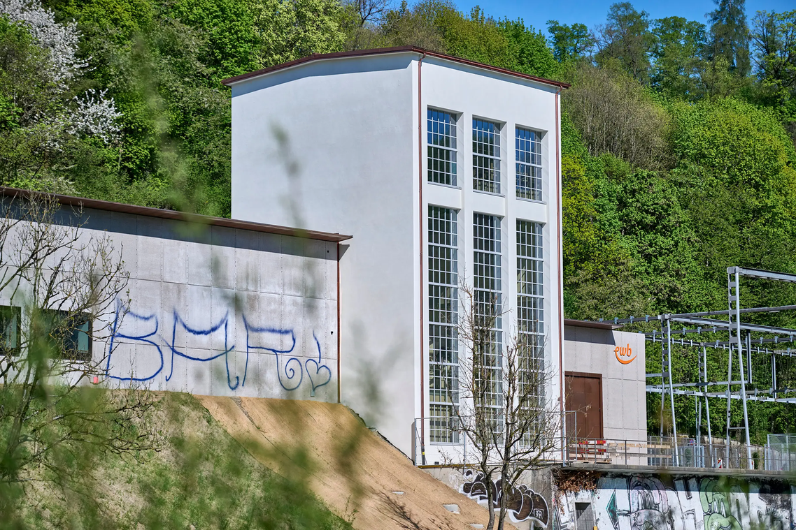 Weihnachtsschmuck verziert ein Baustellengitter, im Hintergrund ein Mehrfamilienhaus
